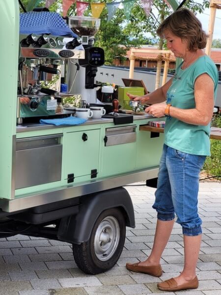 Senta neben der Ape macht Kaffee